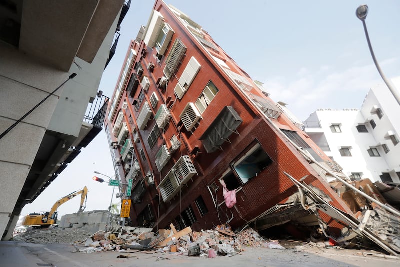 Debris surrounds a titled building days after a powerful earthquake struck in Hualien City (Chiang Ying-ying/AP)