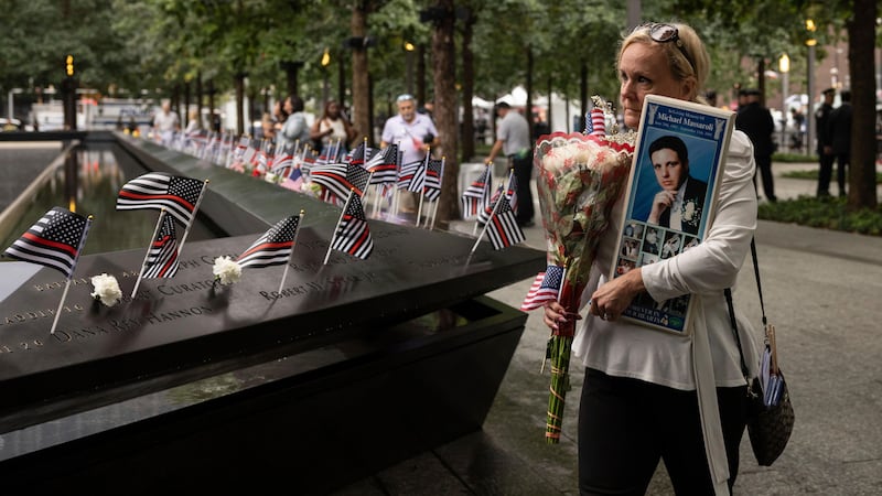 Diane Massaroli holds a picture of her late husband, Michael Massaroli, before the commemoration ceremony of the September 11 attacks (Yuki Iwamura/AP)