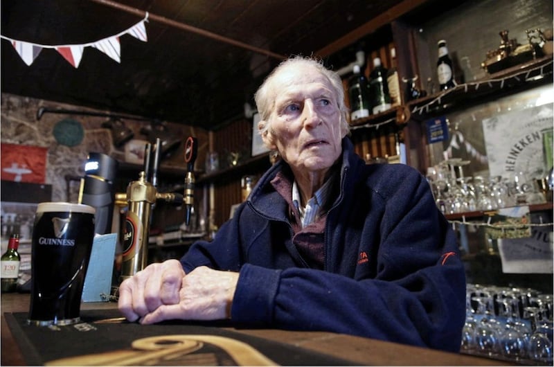 93-year-old Henry Kavanagh behind the counter in his Co Down bar. Picture by Hugh Russell 