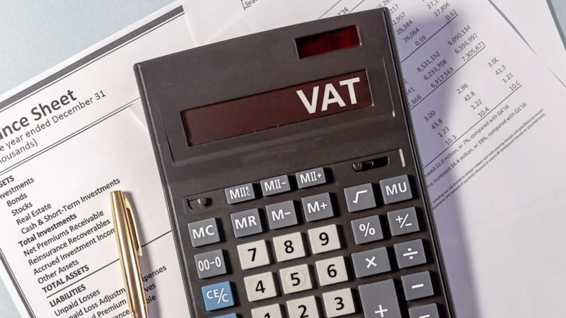 VAT word on display of calculator on papers documents and golden pen 