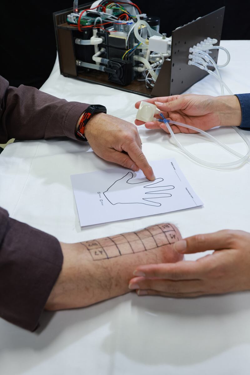 Description: Amputee Fabrizio Fidati showing, on a drawing of a hand, where he feels the temperature sensation from the MetaTouch device 