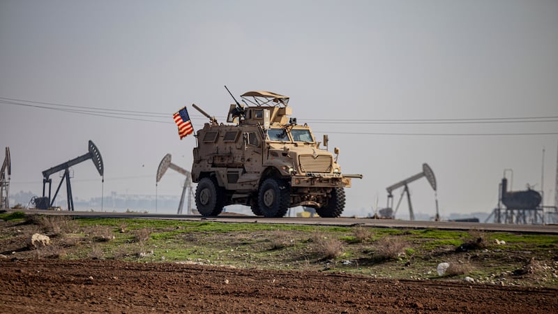 A US military vehicle drives through the countryside near the town of Qamishli, Syria (Baderkhan Ahmad/AP)