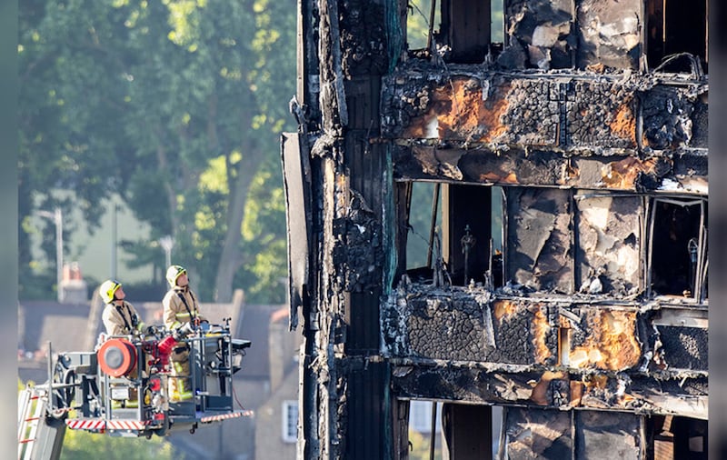 Fire service personnel survey the damage to Grenfell Tower. Picture by Rick Findler, PA Wire