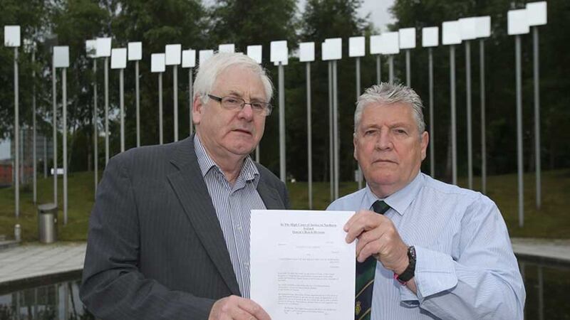 Michael Gallagher (left) who lost his son Aiden, and Stanley McComb (right), who lost his wife Ann in the Omagh bombing hold a writ in the Omagh Memorial Garden&nbsp;