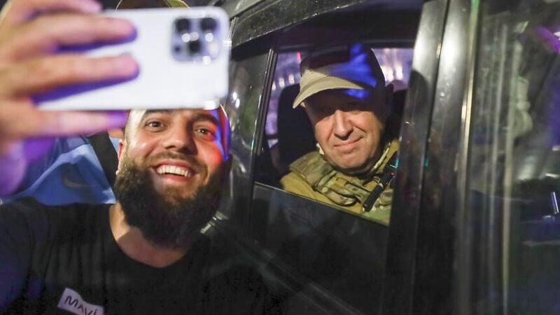 Yevgeny Prigozhin, the owner of the Wagner Group military company, right, sits inside a military vehicle posing for a selfie photo with a local civilian on a street in Rostov-on-Don, Russia, on Saturday (AP)