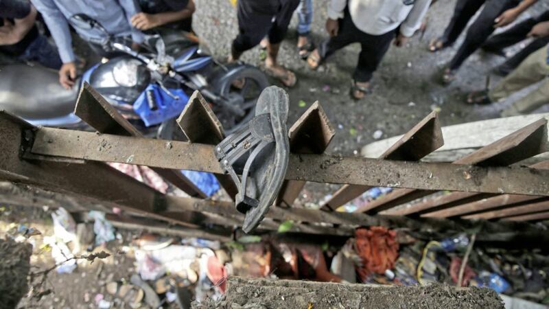 A slipper of an injured commuter is seen stuck on the railing of a pedestrian bridge where a stampede took place at the Elphinstone station, in Mumbai, India, Friday. The stampede broke out on a crowded pedestrian bridge connecting two railway stations in Mumbai during the Friday morning rush, killing a number of people police said PICTURE: Rafiq Maqbool/AP 
