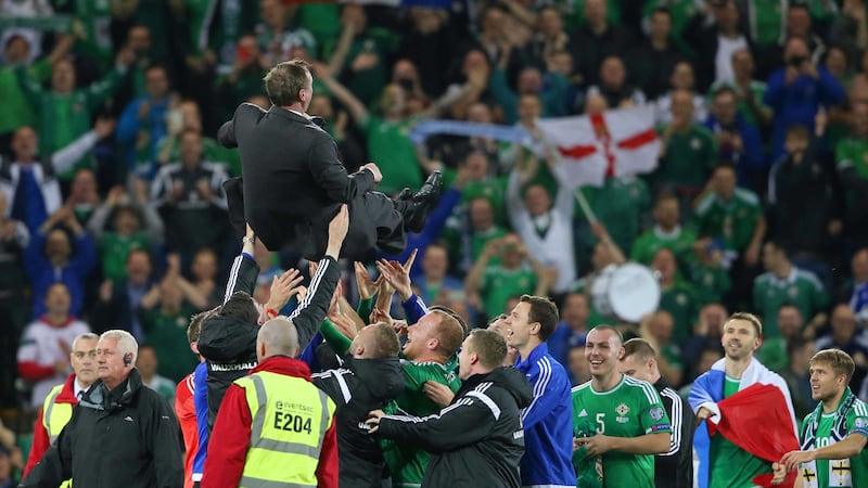 &nbsp;Northern Ireland players throw manager Michael O'Neill in the air after qualification to Euro 2016<br />Picture by Niall Carson