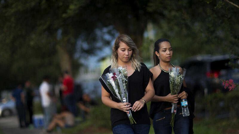 Mourners carry flowers to the funeral home gathering for Pulse nightclub shooting victim Javier Jorge-Reyes in Orlando, Florida. Picture by David Goldman, Associated Press 