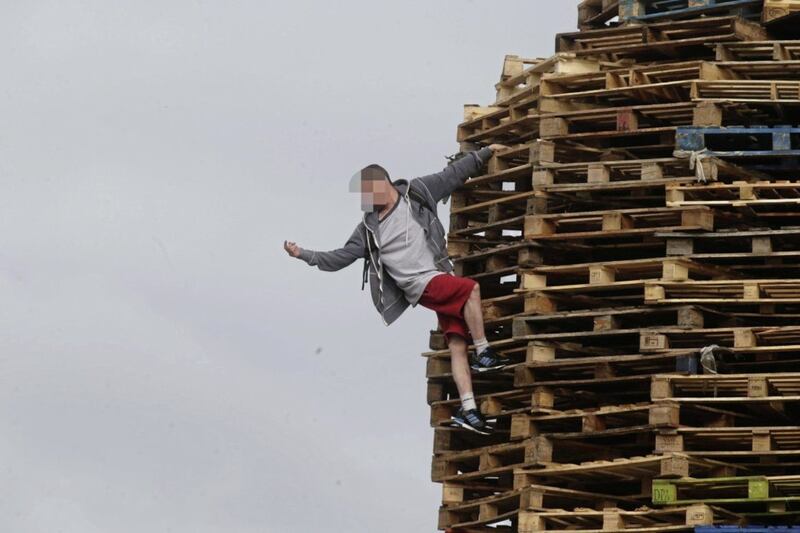A youth climbs on the bonfire built at Victoria Parade. 