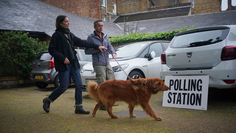 Cinna, an eight-year-old rescue dog from Greece, arrives with its owners at the polling station at St Alban’s Church, south London