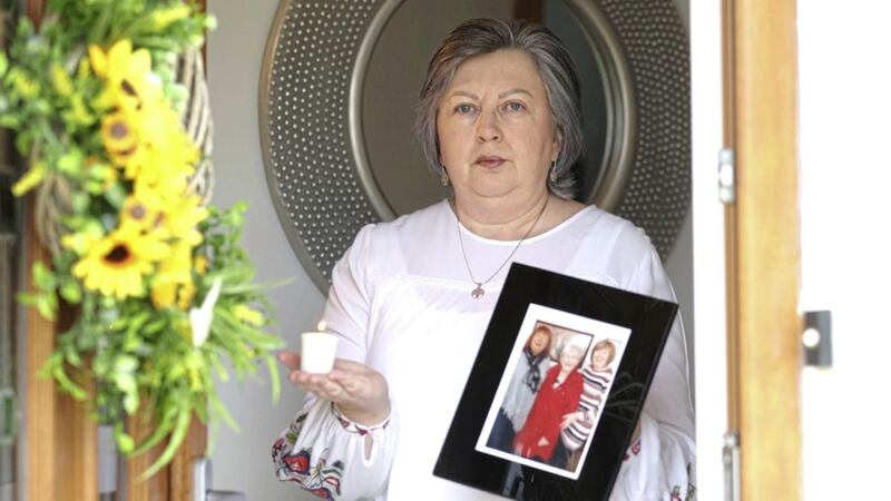 Brenda Doherty&#39;s mother, Ruth (82), was the first female victim of coronavirus. She held a photograph of her mother and lit a candle on the doorstep of her Jordanstown, Co. Antrim home. Picture by Stephen Davison 