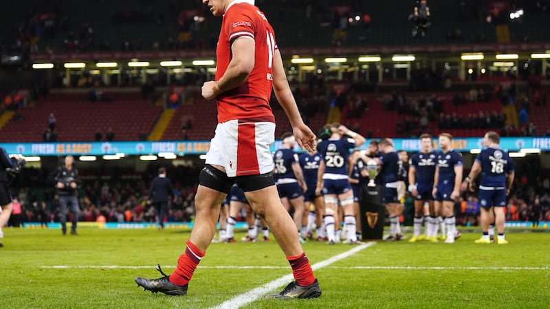 Wales’ Teddy Williams walks past as Scotland players celebrate with the Doddie Weir Cup