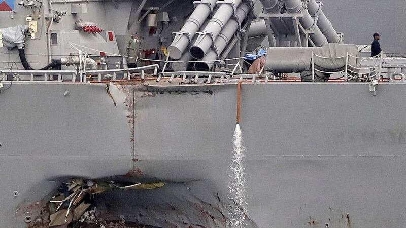The damaged port aft hull of the USS John S McCain, is visible while docked at Singapore&#39;s Changi naval base on Tuesday. Picture by Wong Maye-E, Associated Press 