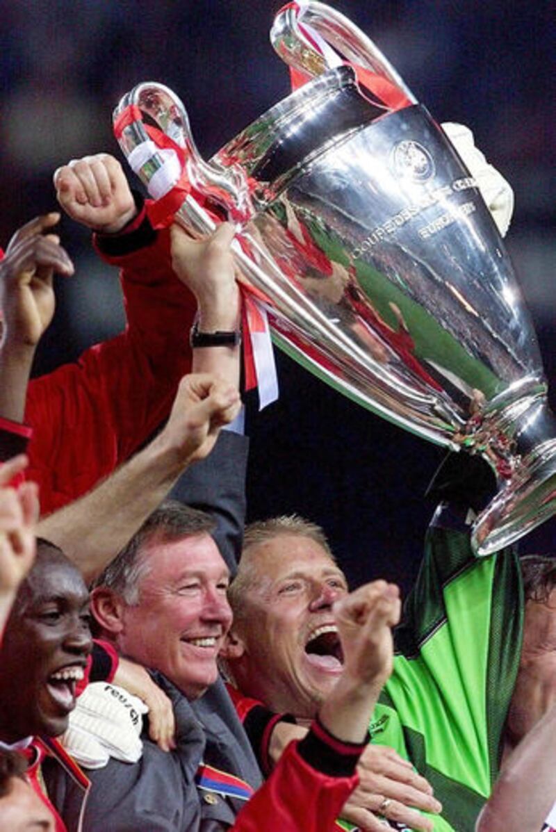 Manchester United striker Dwight Yorke (left) celebrating with the European Cup alongside United boss Alex Ferguson and goalkeeper Peter Schmeichel (right) on May 26 1999