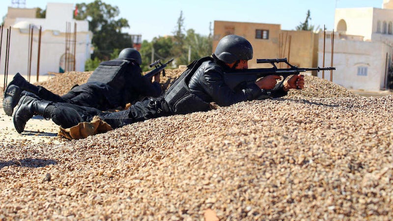 Tunisian police officers take positions as they search for attackers still at large in the outskirts of Ben Guerdane, southern Tunisia, 