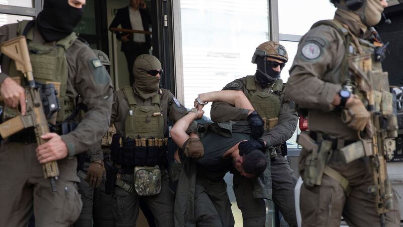 Kosovo police members of the Special Intervention Unit escort one of the arrested Serb gunmen out of court in Pristina, following a shootout at the weekend (Visar Kryeziu/AP/PA)