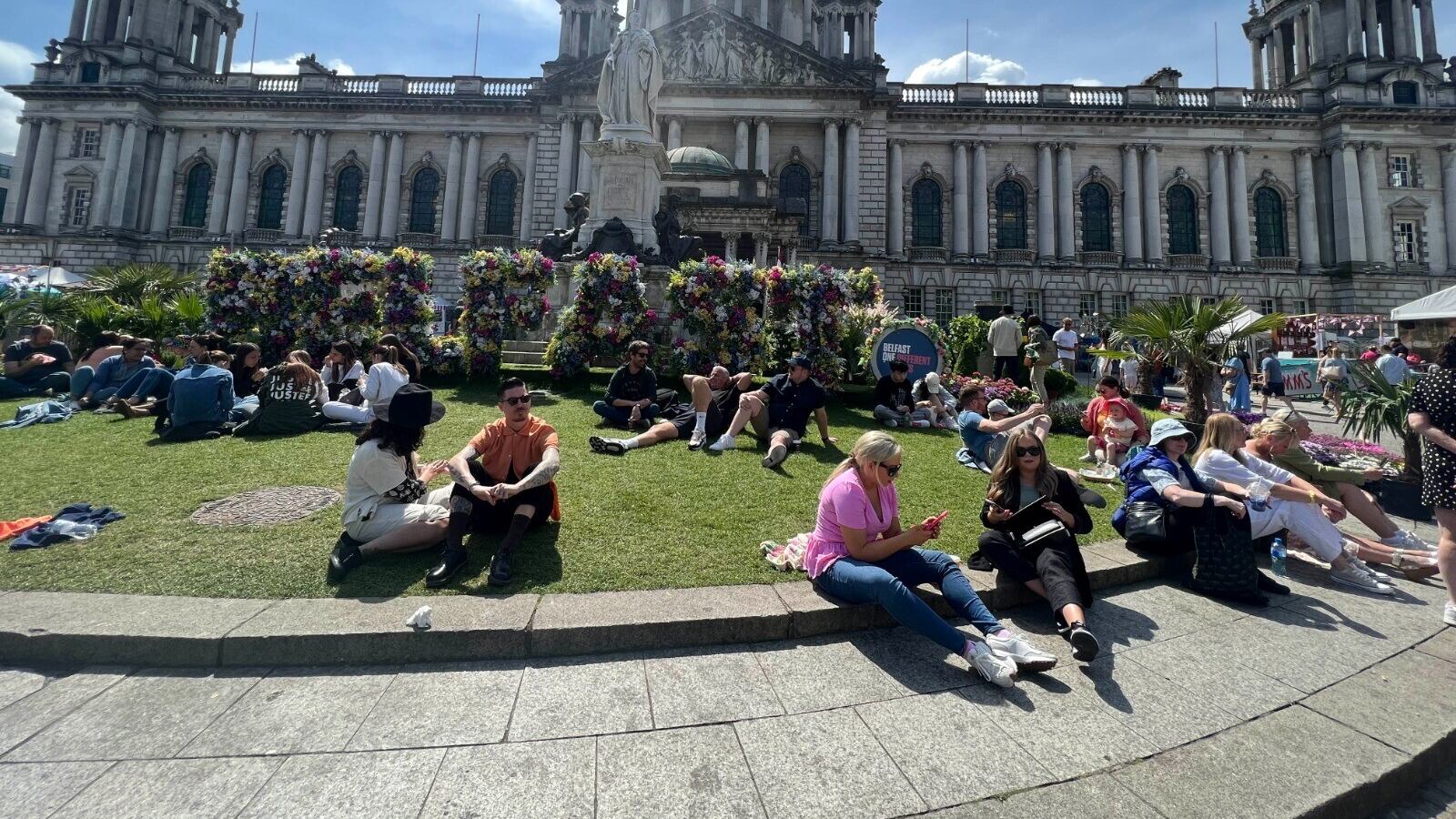 People enjoying the sunshine outside Belfast City Hall