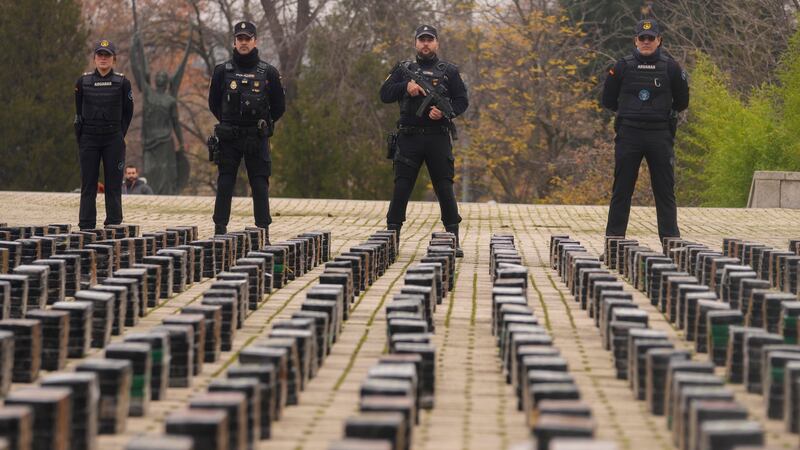 Police officers stand by part of a haul of 11 tons of cocaine, displayed in the patio of a police station in Madrid, Spain (AP Photo/Paul White)