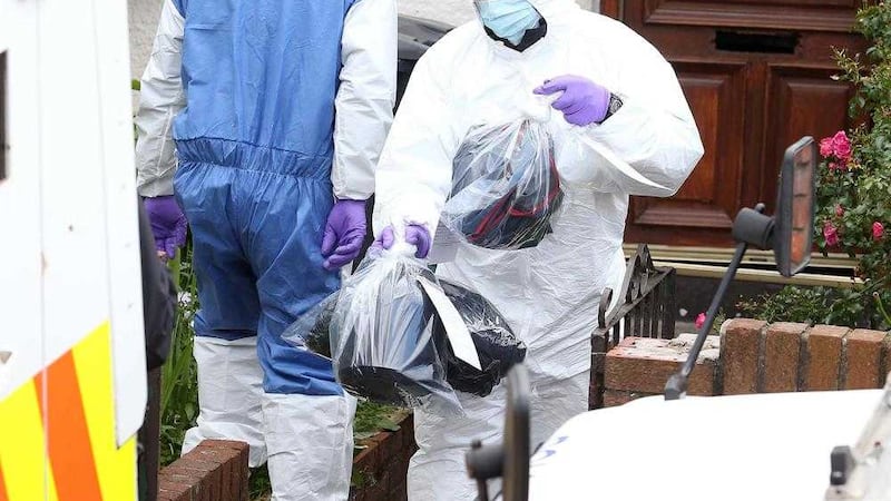 Police forensic officers remove items from a house in the Ballymurphy area following a police operation. Picture Mal McCann 