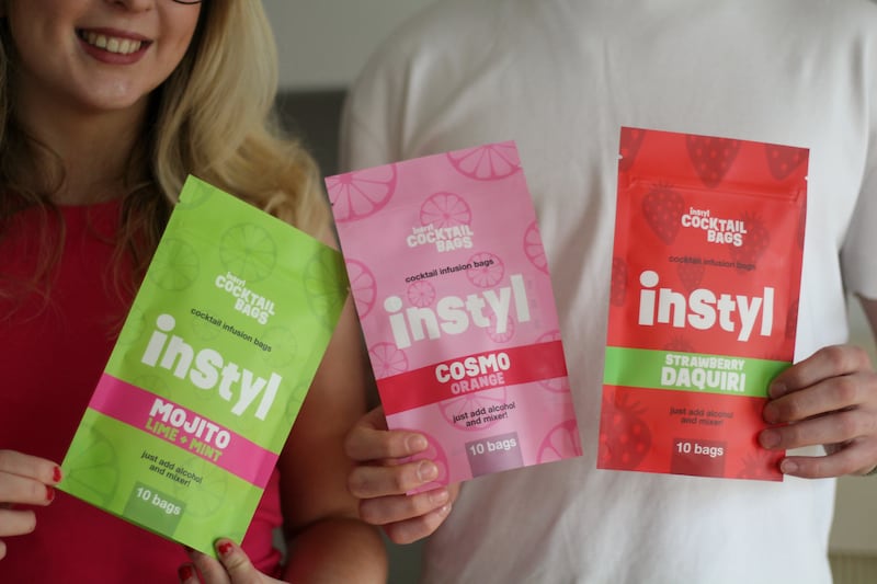 Photo of the products. A green packet saying 'Instyl Mojito lime mint,' a pink packet saying 'Instyl Cosmo orange,' and a red packet saying 'Instyl Strawberry Daquiri.'