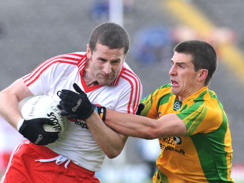 Tyrone captain Stephen O'Neill holds ball tight as Donegal's Paddy McGrath closes in. Picture by Pat McSorley.&nbsp;