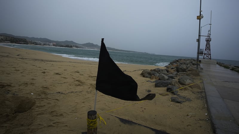 A black flag waves in the wind, signalling a closed beach, in Cabo San Lucas, Mexico (Fernando Llano/AP)