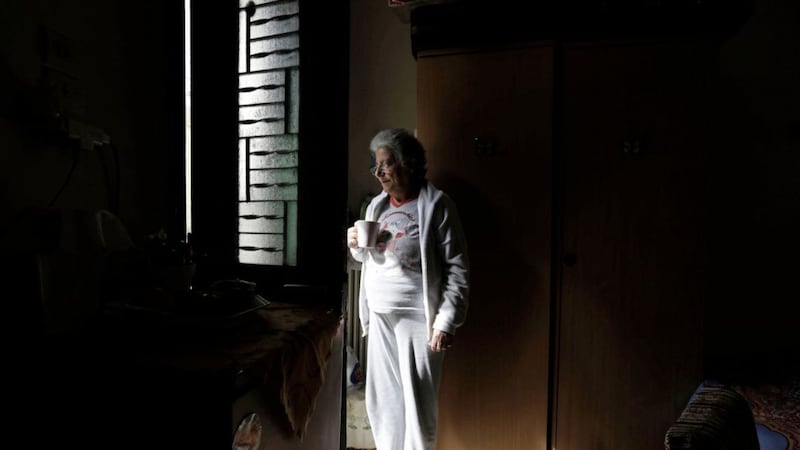 Cancer patient Angeliki Garoufalia, a 62-year-old retired nurse, stands at the door of her room of a homeless shelter run by the Church of Greece, in Athens. High unemployment and a steady decline of living standards for most Greeks for seven consecutive years have left scars on the Greek capital Picture: Thanassis Stavrakis/AP 