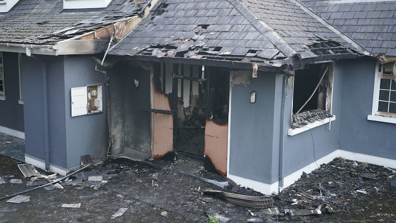 A blue house with fire damage after an arson attack