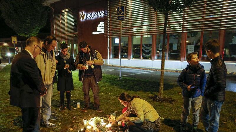 People light candles and lay flowers outside the Swedish school where a masked man killed two people. Picture by Adam Ihse, TT 