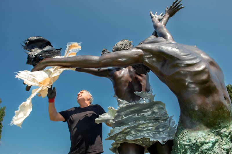 Installer Derek Lahiff applies some final touches to Patrick Campbell's 4.6m bronze sculpture Wind and Sea (Michael Mac 