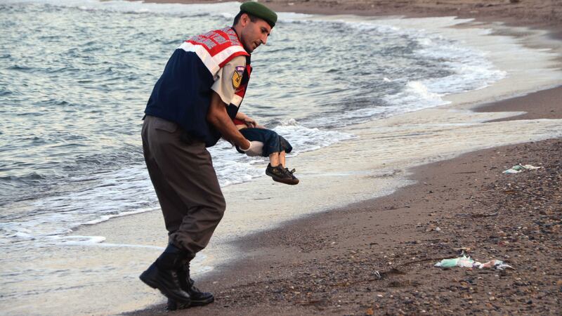 A Turkish police officer carries the body of Aylan Kurdi in a photograph that has been shared around the world