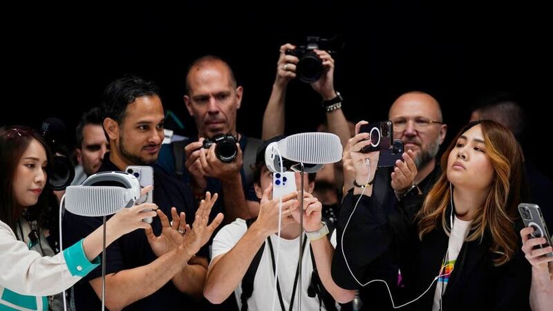 A crowd gathers around the Apple Vision Pro headset as it is displayed in a showroom on the Apple campus (AP Photo/Jeff Chiu)