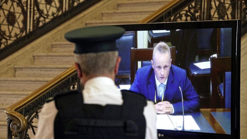 A PSNI officer watches Jamie Bryson on a screen in the Great Hall at Stormont during his controversial appearance before the finance committee&#39;s Nama inquiry in September 2015. Picture Mal McCann. 