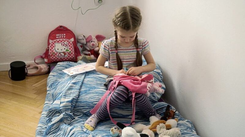 Alisa (5) sits in the bedroom of a Warsaw apartment that Habitat for Humanity Poland helped secure as part of a partnership with the city to house refugees from Ukraine. When fleeing central Ukraine, Alisa&#39;s mother Marina said she could fill one backpack with whatever she wanted. She chose her favourite stuffed animals. Picture from Habitat for Humanity 