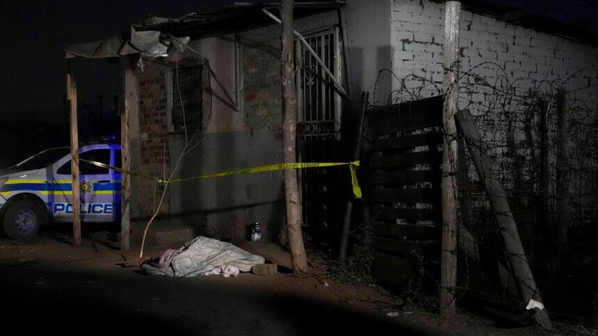 A body lies covered in the Angelo settlement in Boksburg, South Africa (Themba Hadebe/AP)