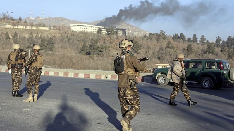 Afghan security personnel stand guard as black smoke rises from the Intercontinental Hotel after an attack in Kabul, Afghanistan PICTURE: Rahmat Gul/AP 