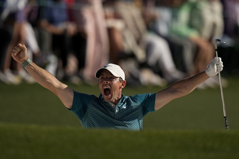 McIlroy celebrates wildly after holing a bunker shot on the 18th green to complete a final round of 64 at last year's Masters, which was enough to give him second place behind Scottie Scheffler Picture by AP