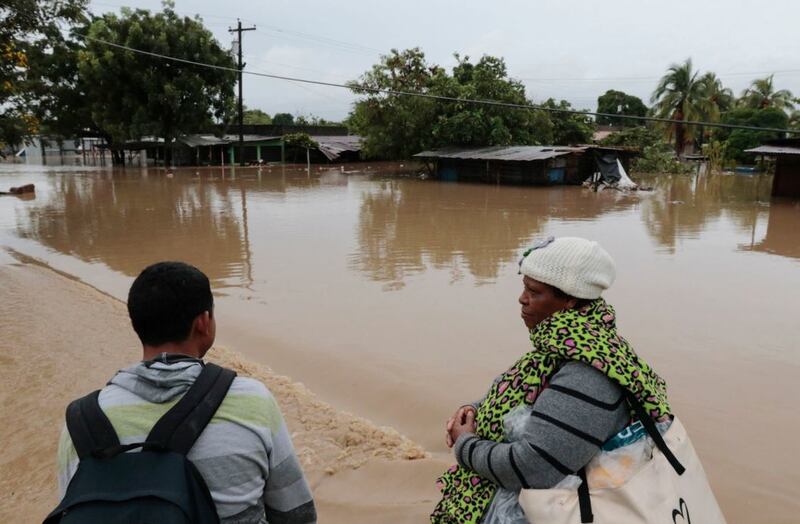 People stand by a flooded street near a river that overflowed its banks after the passing of Hurricane Iota in La Lima, Honduras, on November&nbsp;18 2020. Picture by&nbsp;Delmer Martinez, AP
