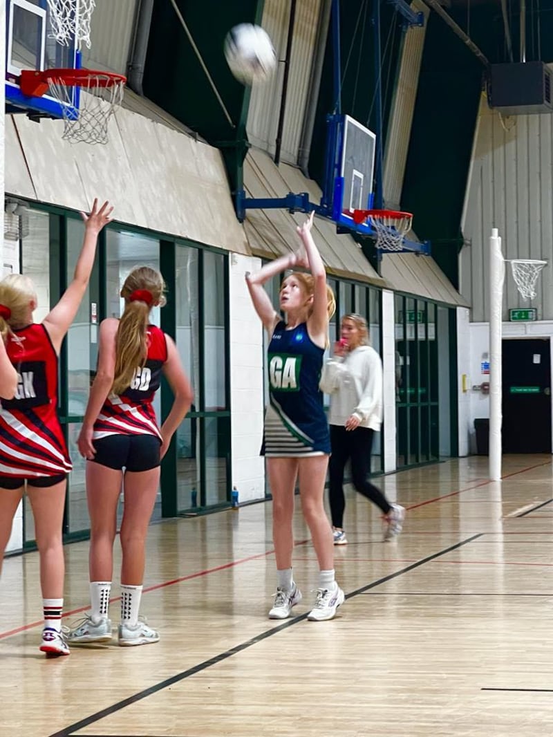 Eleanor throwing the ball into the net during a netball game 