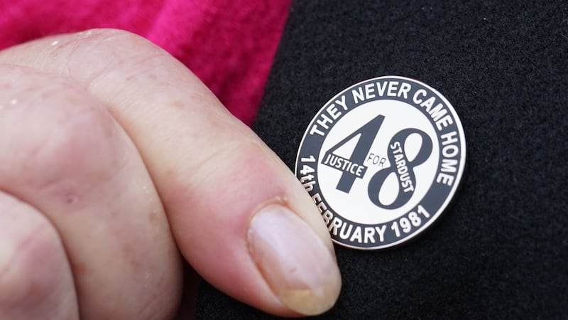 A family member touches her Stardust lapel pin on her way into Dublin Coroner’s Court