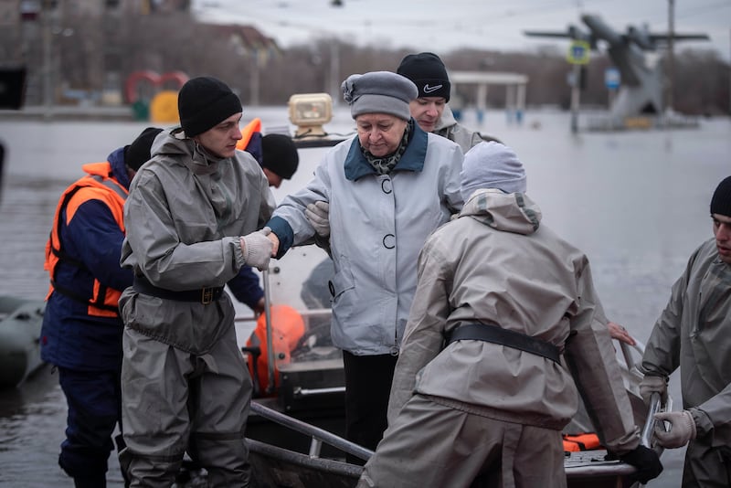 Emergency workers assist a woman during the evacuations (AP)