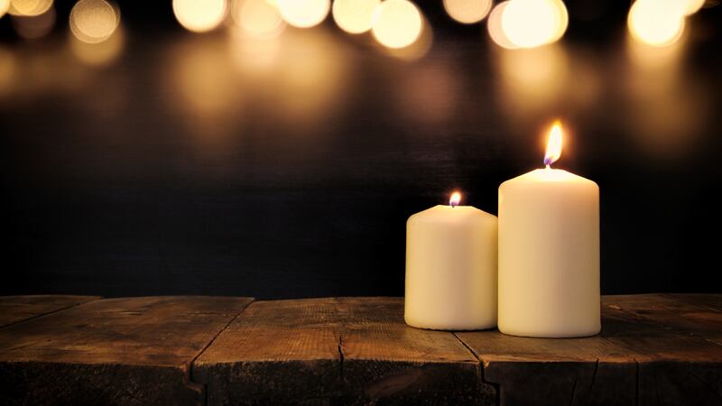 Candles burning on wooden table