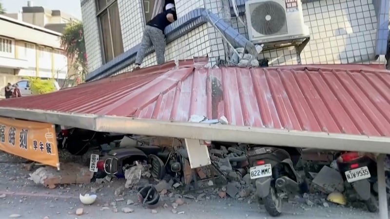 A man checks a partially collapsed building in Hualien, eastern Taiwan (TVBS via AP)