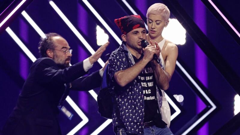A stage invader takes the microphone of SuRie, right, as a security staff member approaches during the Eurovision Song Contest final. Picture by Armando Franca/ AP 