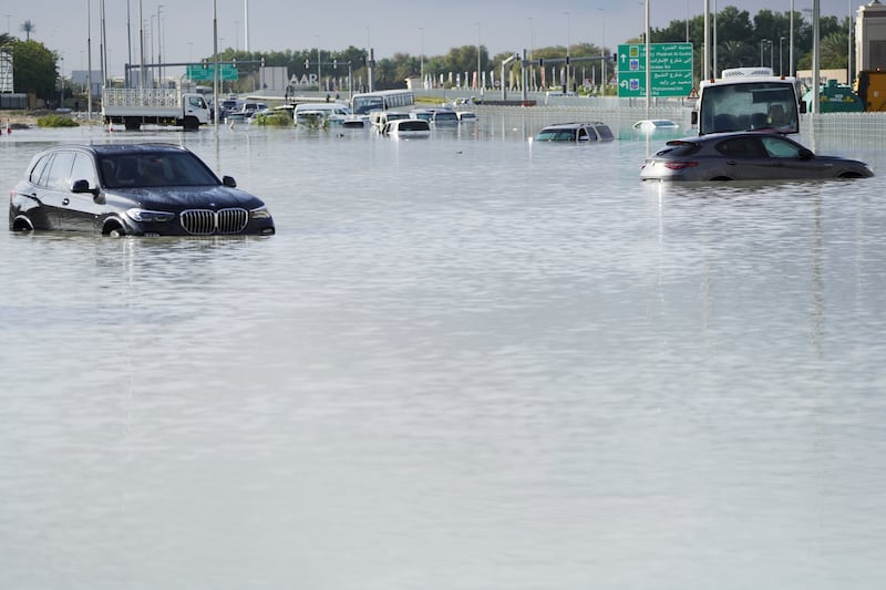 Vehicles sit abandoned in floodwater covering a major road in Dubai (Jon Gambrell/AP)