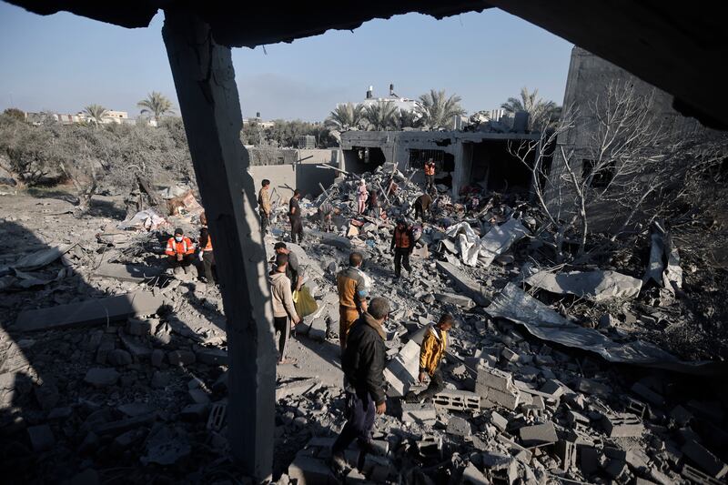 Palestinians inspect the damage of a destroyed house following Israeli air strikes on Khan Younis (Mohammed Dahman/AP)