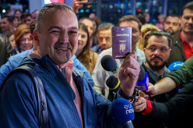 A passenger who arrived on a flight from Vienna shows his passport after becoming one of the first people to take advantage of Romania’s entry into the Schengen area (Andreea Alexandru/AP)