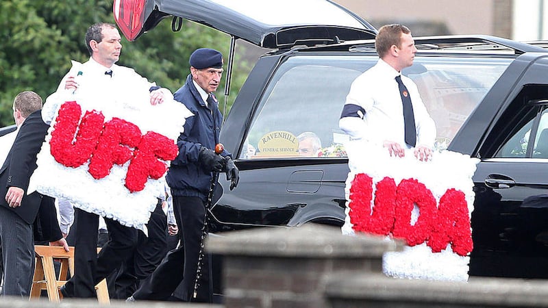 Paramilitary wreaths are carried at the funeral of UDA commander Colin &#39;Bap&#39; Lindsay in south Belfast 
