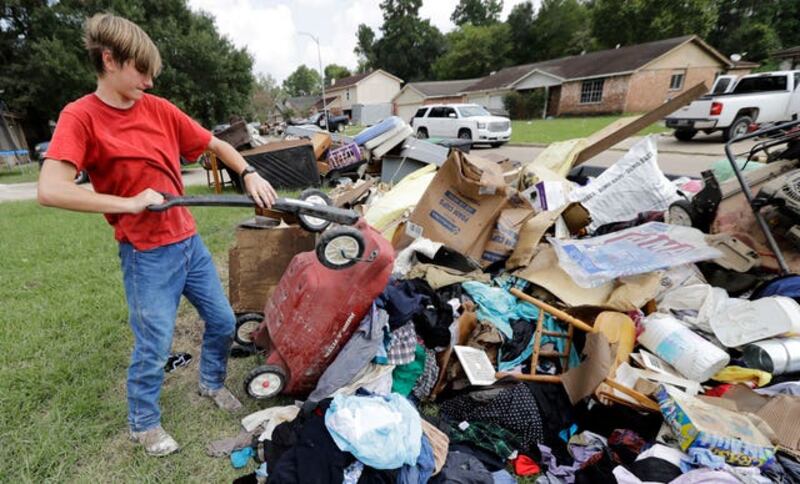 Volunteer Alex Brewer removing items from the home of Julia Lluvia (David J. Phillip/AP)