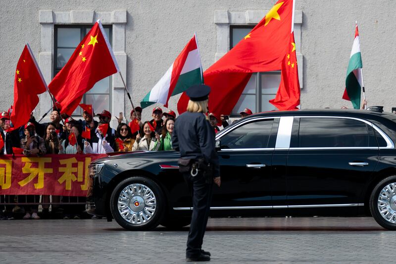 People wave Chinese and Hungarian flags for the Chinese President Xi Jinping outside the Buda Castle in Budapest, Hungary (Denes Erdos/AP)